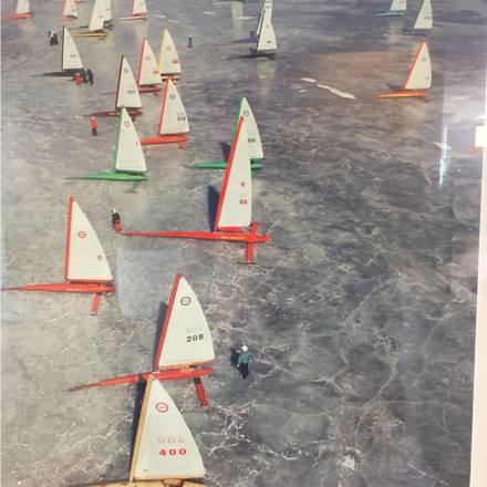 A fleet of small sailing dinghies seen from above.